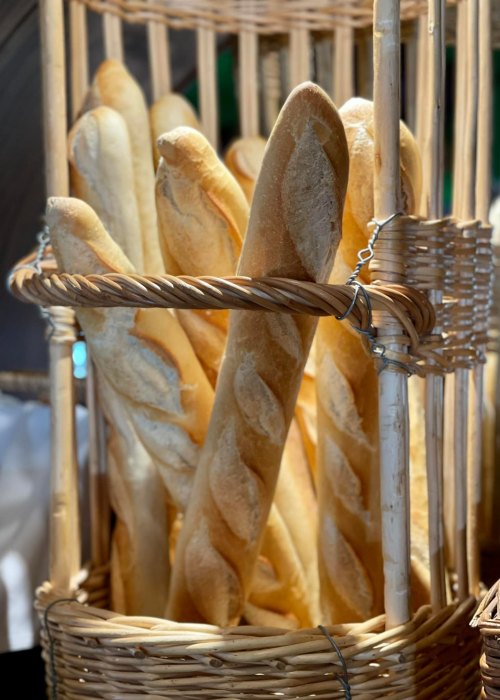 A basket filled with freshly baked baguettes, showcasing their golden crust and elongated shape.