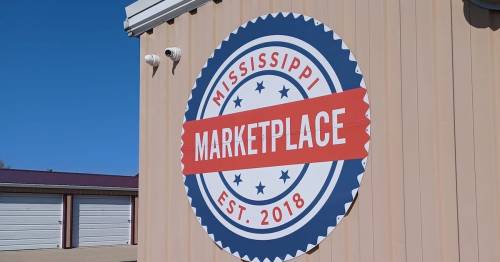 Sign for Mississippi Marketplace, established in 2018, featuring a circular design with stars and bold lettering.