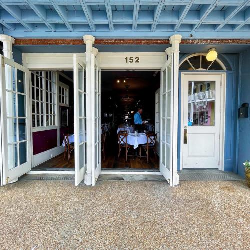 A restaurant entrance with open double doors, revealing a cozy dining area and a welcoming atmosphere.