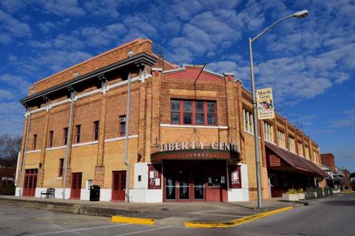 Historic Liberty Center building with a red marquee, set against a blue sky with scattered clouds.