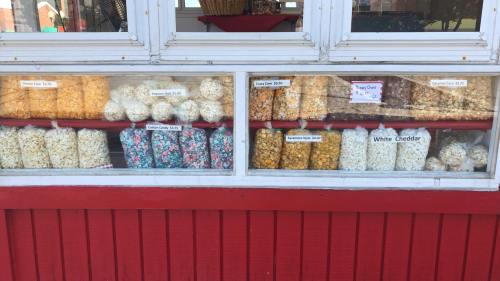 A display window filled with various bags of popcorn in different flavors and colors.
