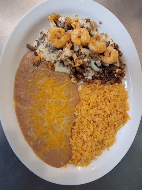 A plate with seasoned shrimp, ground meat, refried beans topped with cheese, and yellow rice.