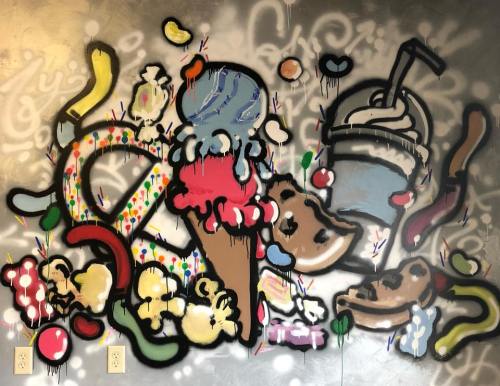 Colorful graffiti mural featuring ice cream cones, sweets, and playful designs on a metallic background.