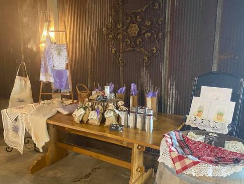 A rustic display of handmade goods, including bags, candles, and art, on a wooden table in a cozy setting.