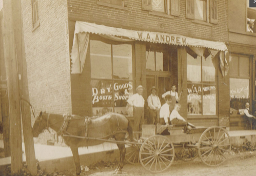 A historic photo of a horse-drawn cart outside W.A. Andrew's store, with several men posing in front.