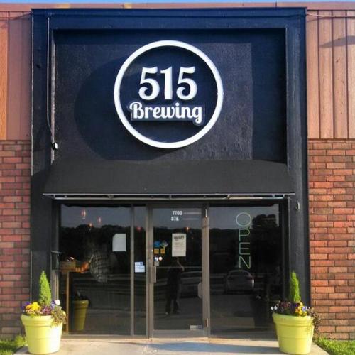 Exterior of 515 Brewing with a large sign, open door, and planters on either side.