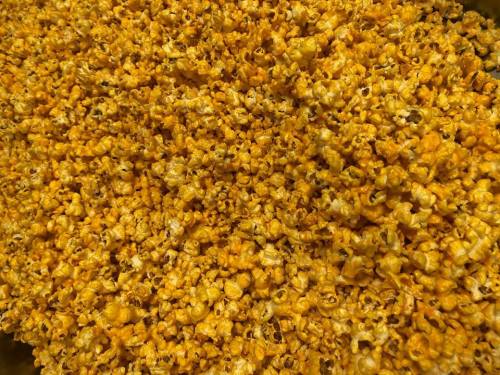 A close-up of a large pile of buttery, yellow popcorn.