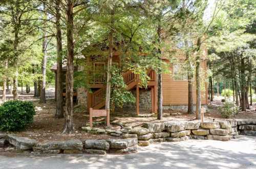 A wooden lodge surrounded by trees, with a stone pathway and a sign indicating "Lodge 10."