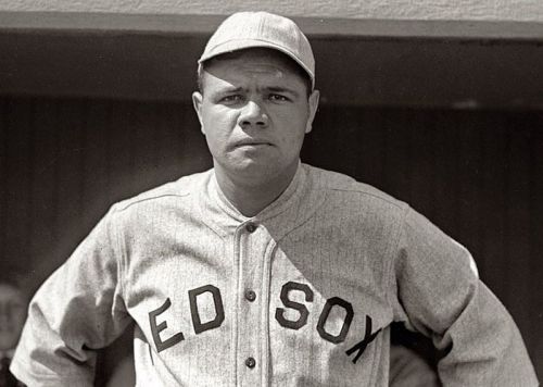 A vintage black-and-white photo of a baseball player in a gray jersey with "ED SOX" written on it, wearing a cap.
