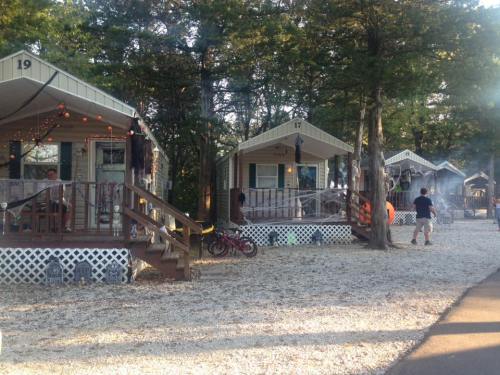 Cottages decorated for Halloween, with cobwebs and spooky decor, surrounded by trees and gravel paths.