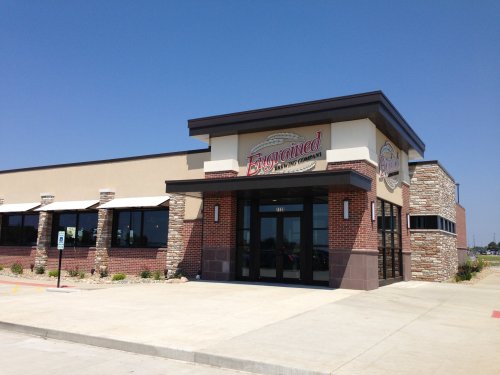 Exterior of a restaurant named "Engrained," featuring a modern design and stone accents under a clear blue sky.