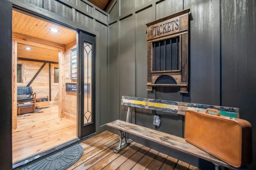 Entrance with a wooden bench, vintage ticket booth, and a cozy interior visible through the open door.