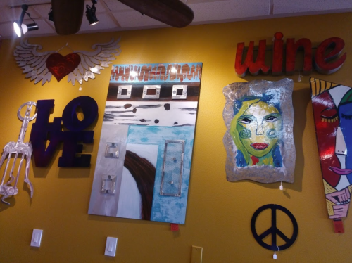 Colorful wall art featuring the words "LOVE" and "wine," along with abstract faces and decorative elements.