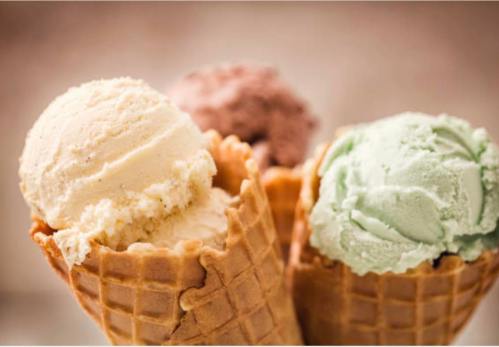 Three ice cream cones with scoops of vanilla, chocolate, and mint flavors against a soft background.