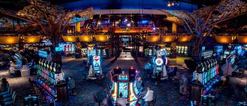 A vibrant casino interior filled with slot machines and colorful lights, bustling with people enjoying games.