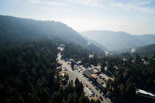 Aerial view of a mountainous landscape with winding roads and a small town nestled among the trees.