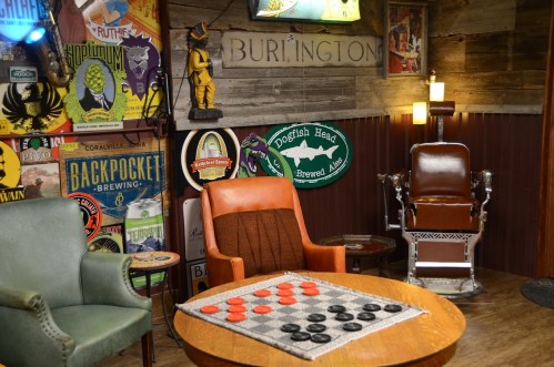 Cozy game room with vintage decor, two chairs, and a checkers board on a wooden table.