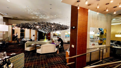 A modern restaurant interior featuring stylish seating, artistic decor, and ambient lighting.