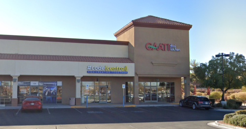 Exterior view of a shopping center featuring a Thai kitchen and a "#code(central)" sign, with parking in front.