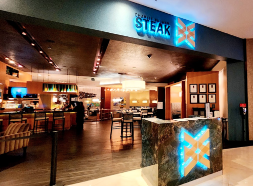 Entrance to Charlie's Steakhouse, featuring a modern design with blue lighting and a welcoming reception area.