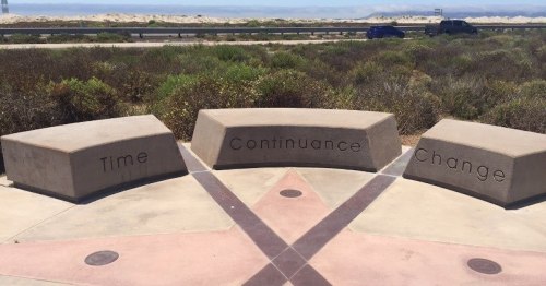 Three stone benches inscribed with "Time," "Continuance," and "Change," set against a natural landscape.