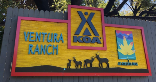 Colorful sign for Ventura Ranch KOA featuring deer silhouettes and a nature-themed graphic.