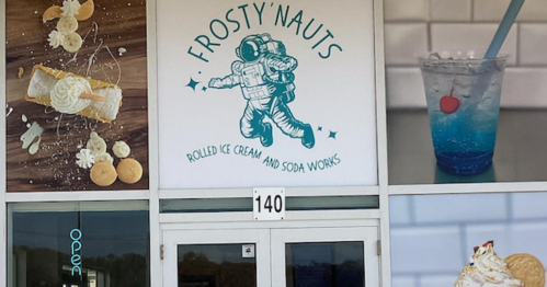 Exterior of Frosty'nauts, featuring an astronaut logo and images of desserts and drinks. Open sign visible.