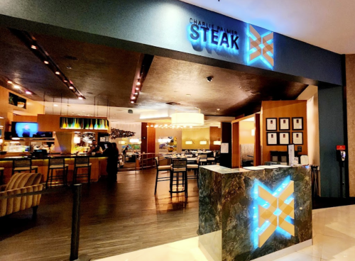 Entrance to Charlie's Steakhouse, featuring modern decor and illuminated signage.