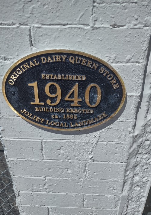 Plaque on a wall marking the original Dairy Queen store, established in 1940, Joliet local landmark.