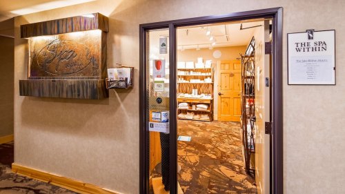 Entrance to a spa with a decorative sign, shelves of products, and a welcoming atmosphere.