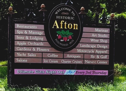 Sign welcoming visitors to Historic Afton, listing attractions like restaurants, marinas, and shops.