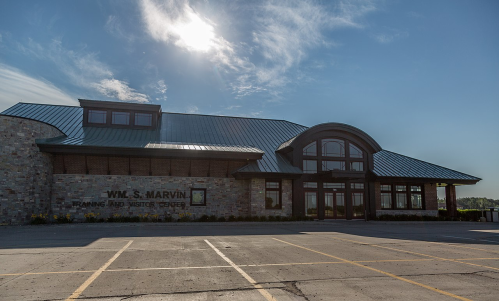 Exterior view of the Wm. S. Marvin Training and Visitor Center, featuring a stone facade and a green metal roof.