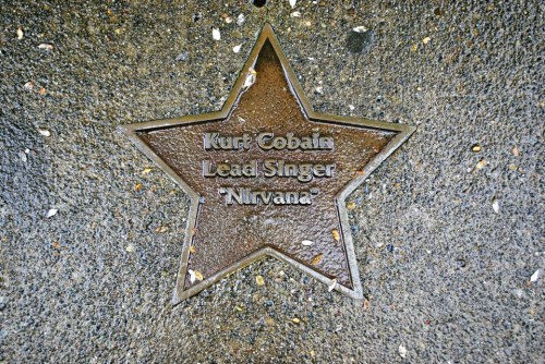 A bronze star embedded in the ground, honoring Kurt Cobain, lead singer of Nirvana.