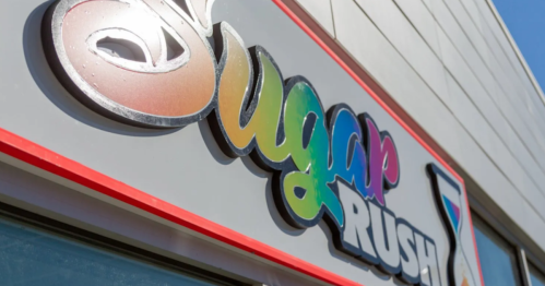 Colorful "Sugar Rush" sign on a building, featuring a playful font and a vibrant design.