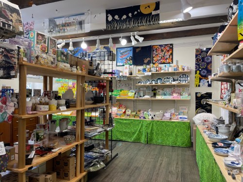 A colorful shop interior filled with various items, including kitchenware, decorations, and crafts on display shelves.