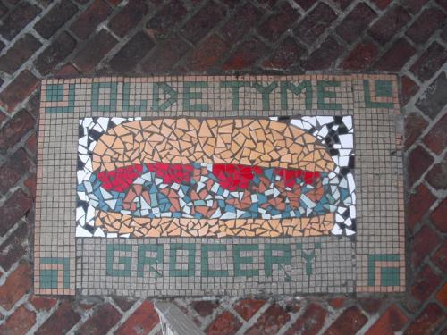 Mosaic tile artwork featuring a sandwich with the text "Golden Time Grocery" below it.