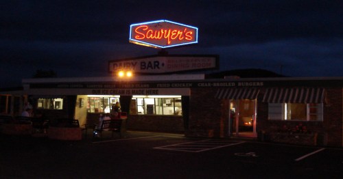 Sawyer's Dairy Bar glowing under its neon sign at night in Gilford, New Hampshire