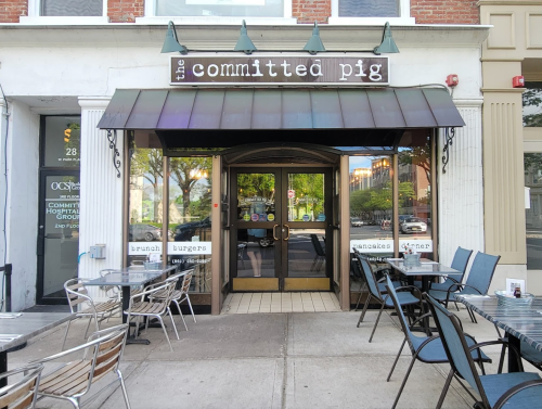 Exterior of "The Committed Pig" restaurant, featuring a welcoming entrance and outdoor seating area.