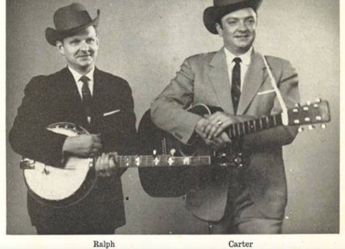 Two men in hats, one with a banjo and the other with a guitar, posing together in black and white.