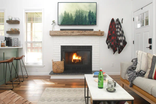 Cozy living room with a fireplace, TV, and rustic decor, featuring a coffee table and a woven basket.
