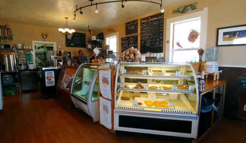 Cozy café interior with a display case of baked goods, a coffee counter, and a warm, inviting atmosphere.