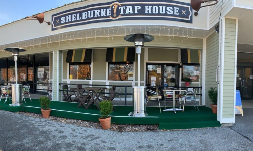 Exterior view of Shelburne Tap House with outdoor seating, heaters, and a welcoming entrance.