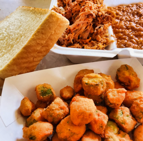A plate featuring fried okra, pulled pork, baked beans, and a slice of bread.