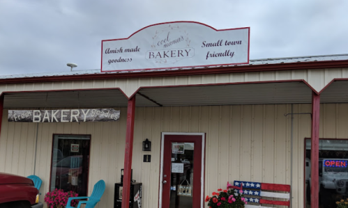 A small-town bakery with a sign reading "Amish made goodness" and an American flag display outside.