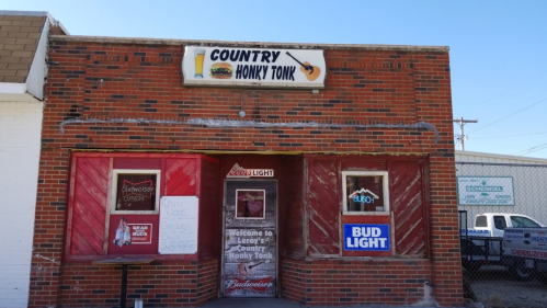 Exterior of a rustic bar named "LeRoy's Country Honky Tonk," featuring signs for Bud Light and chili specials.