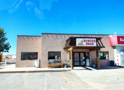 A small restaurant building with a sign reading "Burger Shak" under a clear blue sky.
