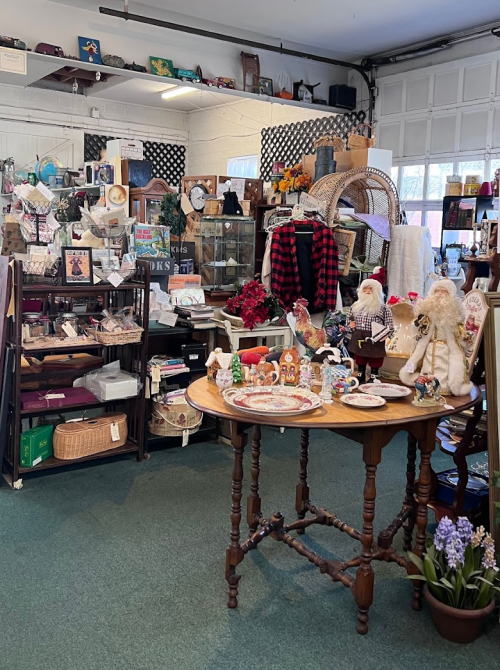 A cozy antique shop filled with various vintage items, decor, and a wooden table displaying collectibles.