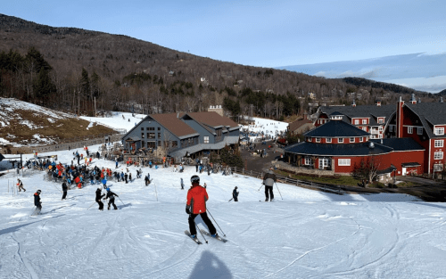 A snowy ski resort scene with skiers on the slopes and a bustling lodge in the background.
