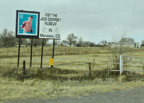 Sign for the Jack Dempsey Museum in Manassa, CO, featuring a stamp image of the famous boxer.