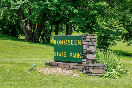 Sign for Bomoseen State Park, surrounded by green grass and trees.